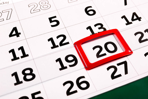 Die Zahl 20 auf dem Kalender ist rot hervorgehoben. Der zwanzigste Tag des Monats. Agenda für heute. Nahaufnahme. - Foto, Bild