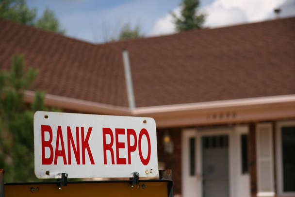 Bank Repo Sign on Home zum Verkauf. Die Wirtschaft steuert angesichts der hohen Arbeitslosigkeit auf das Schlimmste zu. Banken kaufen Häuser zurück, wenn der Eigentümer die Hypothek nicht bezahlen kann. - Foto, Bild