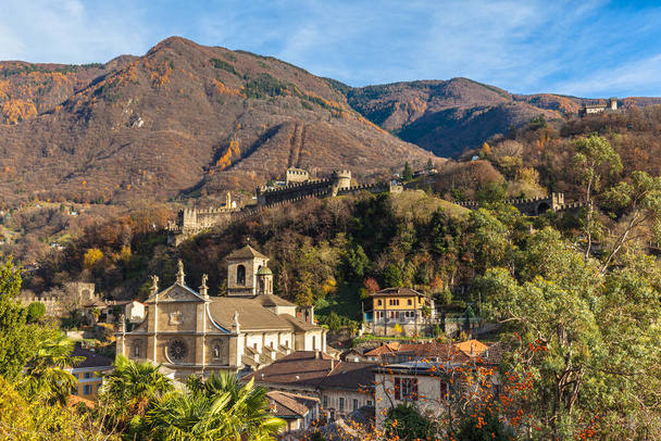 Wspaniały widok na stare miasto Bellinzony z kościołem Chiesa Collegiata dei SS Pietro e Stefano, zamek Castelgrande i Alpy Szwajcarskie w tle, w słoneczny jesienny dzień, Ticino, Szwajcaria - Zdjęcie, obraz