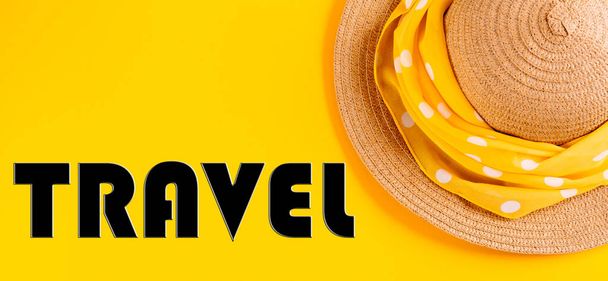 Слово "мандрівник", написане в листах на жовтому тлі з солом'яним капелюхом. Концепція відпочинку, відпустки. Прапор
. - Фото, зображення