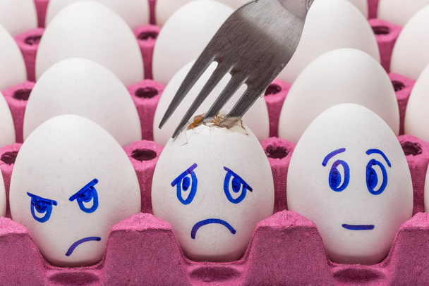 Kawaii se enfrenta a huevos en un cartón con plumas sobre un fondo blanco de cerca. Concepto de dibujos animados, decoración de alimentos para niños
 - Foto, imagen