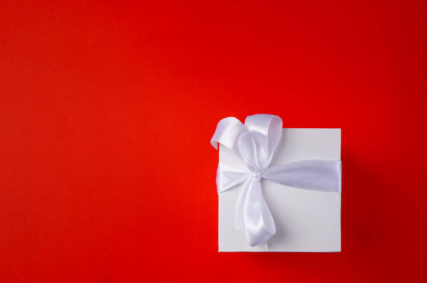  White Gift box on a red background. Space for text.  - Photo, Image