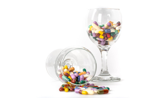 pills and capsules in a glass jar on white background - Foto, Imagen