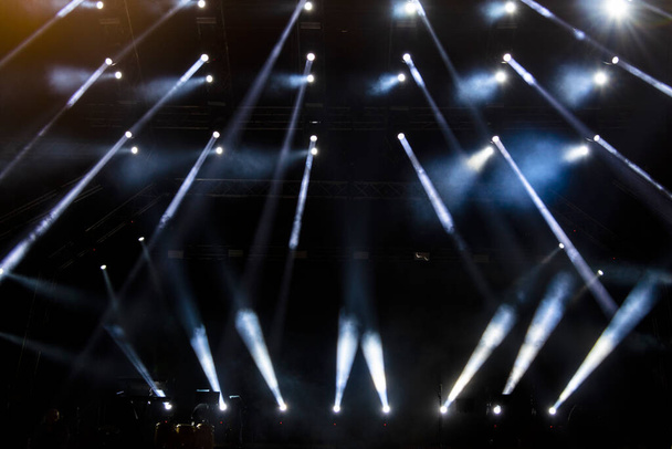 Concertverlichting, podium, show en spanning. Lichtpunten in concert, buitenpodium 's nachts, mistige elektriciteit. - Foto, afbeelding