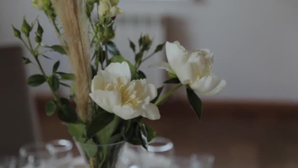 Prachtige bloemen in een glazen vaas op de feestelijke tafel. - Video