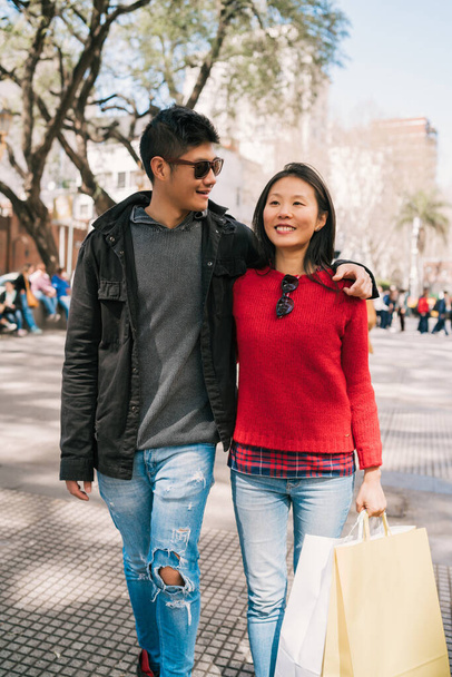 Portrait of young Asian couple in love walking in the city after shopping. Shop concept. - Фото, зображення