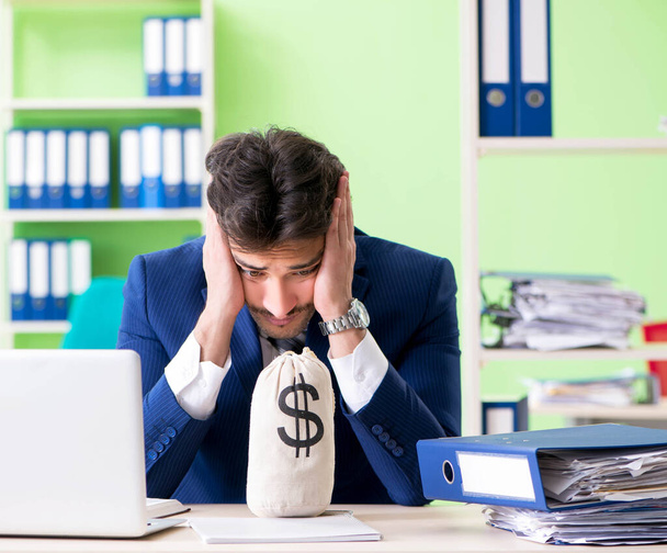 Επιχειρηματίας δυσαρεστημένος με την υπερβολική εργασία κάθεται στο γραφείο - Φωτογραφία, εικόνα