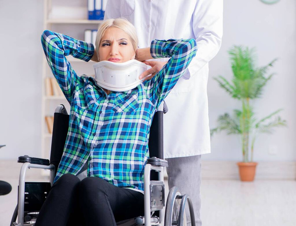 Gehandicapte vrouw in rolstoel op bezoek man arts - Foto, afbeelding