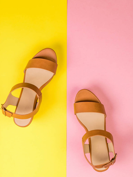 Women's leather sandals on the border of red and yellow background. Flat lay. - Foto, Imagem