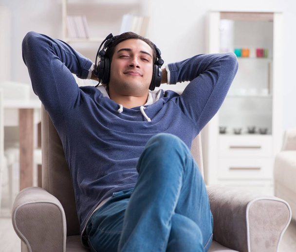 Молодой человек слушает музыку дома - Фото, изображение