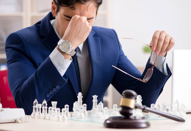 Νεαρός δικηγόρος που παίζει σκάκι για να εκπαιδεύσει την στρατηγική του και τα tacti - Φωτογραφία, εικόνα