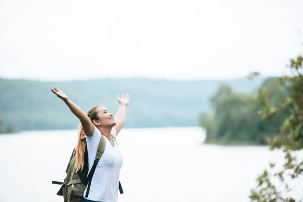Chica turística con los brazos felices con la naturaleza cerca del río. Concepto de viaje
. - Foto, Imagen