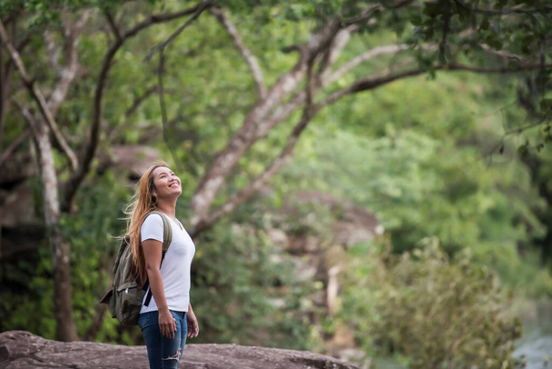 Young tourist woman with backpack enjoy nature standing on top of the mountain. - 写真・画像