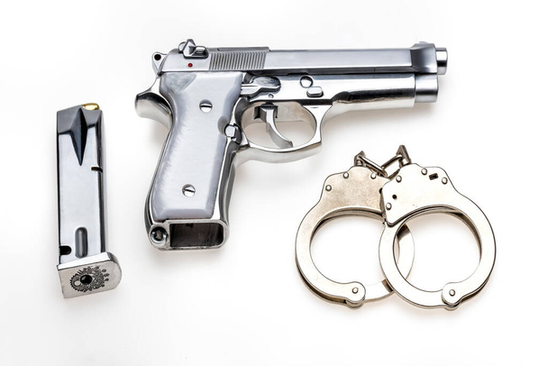 handcuffs and pistol isolated on white background - Фото, изображение
