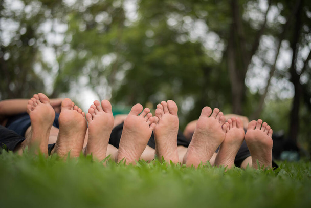 Primer plano de los pies de la familia juntos en el campo verde
. - Foto, Imagen