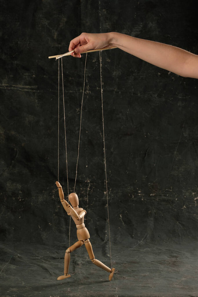 Puppet in the hands of puppeteer walks on isolated, background. Object on a texture background. - Foto, Imagen