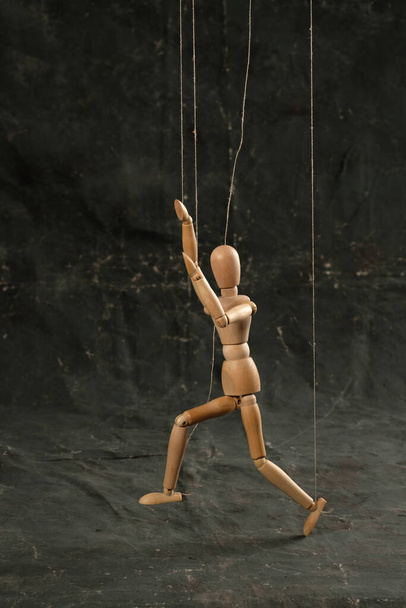 Puppet in the hands of puppeteer walks on isolated, background. Object on a texture background. - Photo, image