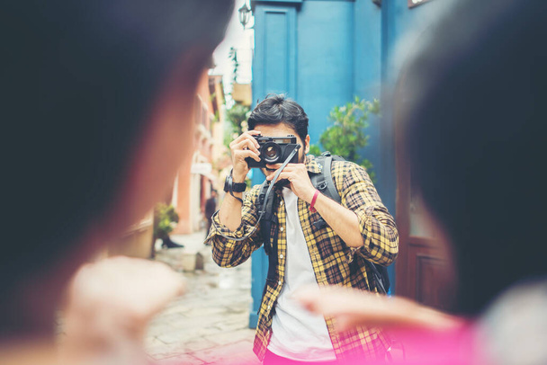 Jongeman neemt selfie van zijn vrienden tijdens het reizen in stedelijke samen. - Foto, afbeelding