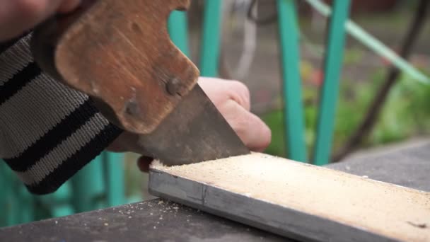 sawing wooden board with rusty old saw at home - Footage, Video
