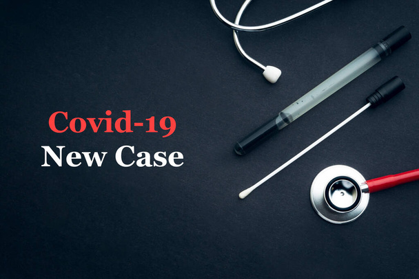 COVID-19 lub CORONAVIRUS NEW CASE tekst ze stetoskopem i wymazem medycznym na czarnym tle. Koncepcja Covid-19 lub Coronavirus.  - Zdjęcie, obraz