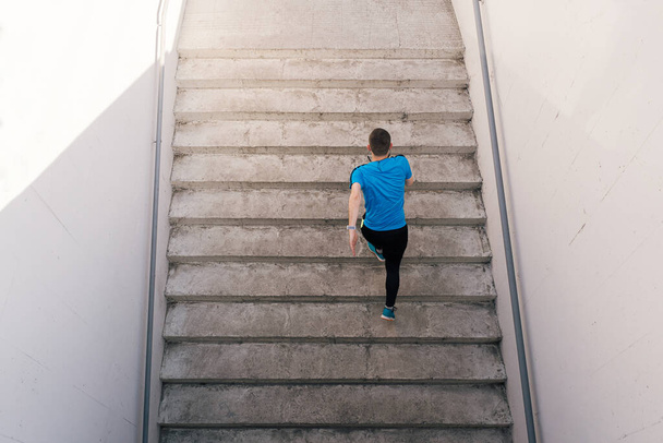 Młody mężczyzna ćwiczy ćwiczenia interwałowe na schodach - Zdjęcie, obraz
