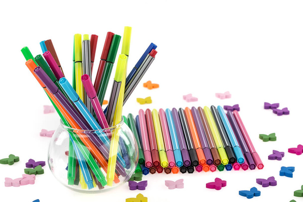 canetas coloridas em cesta de ferro no fundo branco
 - Foto, Imagem