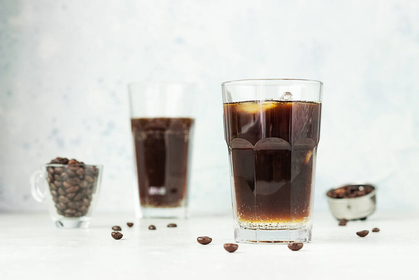 Espresso tonic, refreshment summer drink with tonic water, coffee and ice cubes, light grey background. Trendy coffee drink. - Φωτογραφία, εικόνα