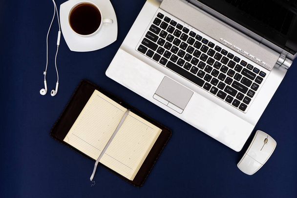 Moderner Arbeitsplatz, Laptop und Zubehör auf blauem Hintergrund - Foto, Bild