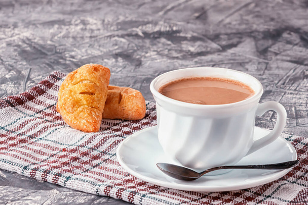 On a gray background coffee with cream and freshly baked puffs - Фото, зображення