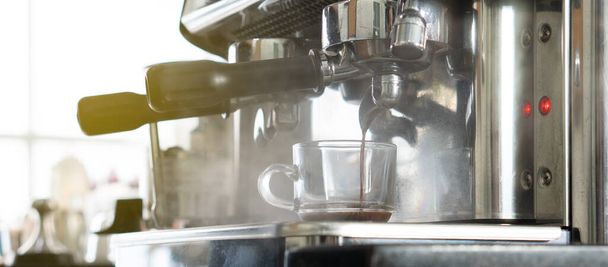 Nahaufnahme einer Kaffeemaschine, die im Restaurant Expresso in eine Tasse brüht. Barista und Café-Konzept - Foto, Bild