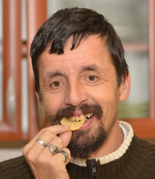 portré, fiatal, barna ember eszik chipek - Fotó, kép