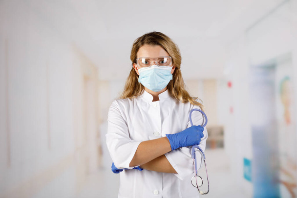 Confident woman doctor wearing medical mask standing with crossed arms. female portrait. - Foto, Imagen