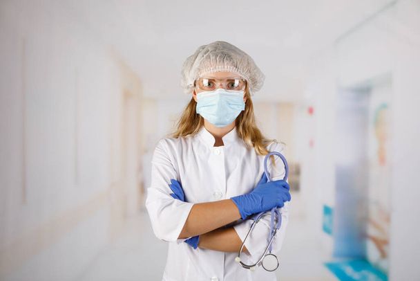 Confident woman doctor wearing medical mask standing with crossed arms. female portrait. - Foto, Bild