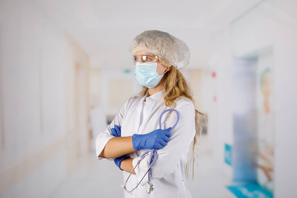 Confident woman doctor wearing medical mask standing with crossed arms. female portrait. - Foto, Bild