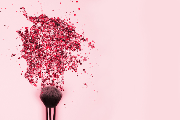 Lähikuva ammatillinen kosmeettinen meikki harja räjähdys kiiltävä vaaleanpunainen värikäs kimaltelee kirkkaan vaaleanpunainen tausta copyspace tekstin. Luovan kokoonpanon käsite - Valokuva, kuva