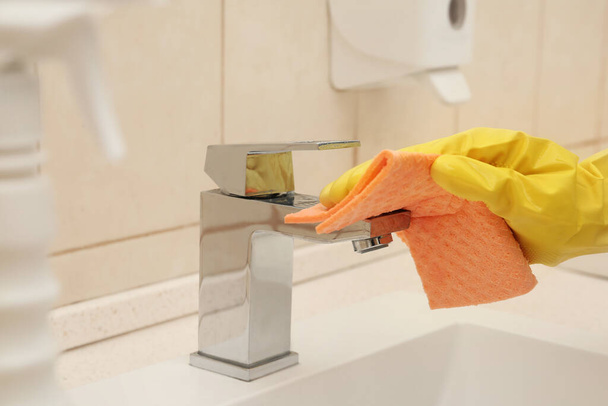 Osobie sprzątanie kran z szmatą w łazience, zbliżenie - Zdjęcie, obraz