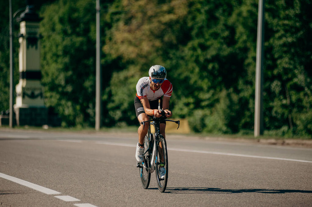 Kharkiv, Ukraine - August 11, 2019: Cycling competition. Triathlete riding at high speed in the sunny day in competition of triathlon - Φωτογραφία, εικόνα