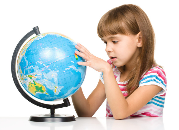 Little girl is examining globe - Фото, изображение