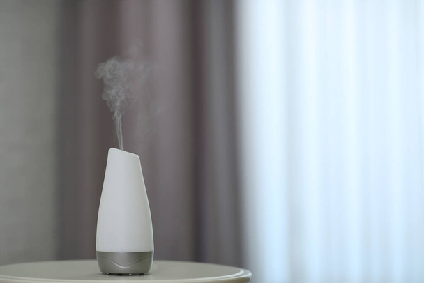 Aroma oil diffuser on table indoors. Space for text - Zdjęcie, obraz