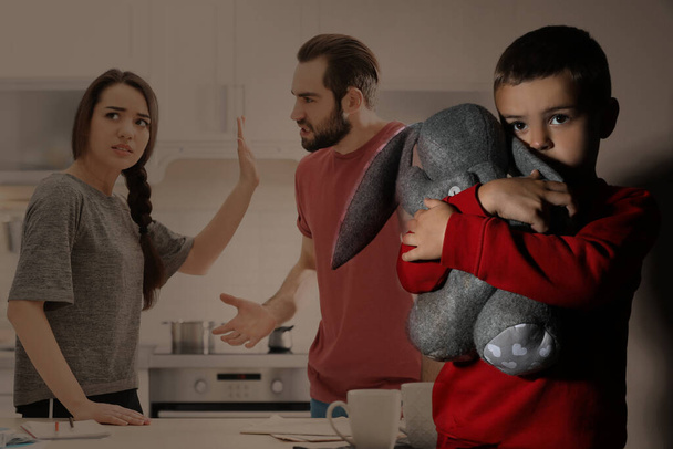 Double exposure of sad little boy with toy and his arguing parents - Foto, imagen