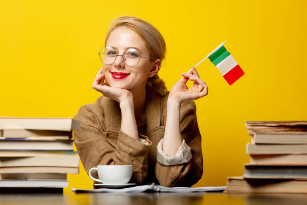 blondýna žena s vlajkou Itálie a knihy na žlutém pozadí - Fotografie, Obrázek