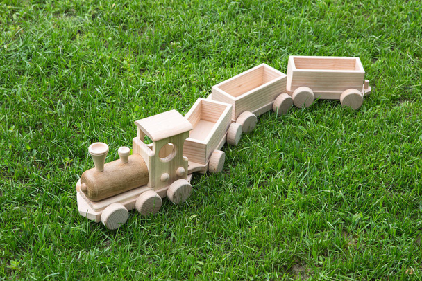 Juguetes de madera para niños. Tren de madera para niños con vagones. Conjunto de construcción de madera natural. Equipo educativo. Locomotora de madera para niños con varios cargamentos en vagones
. - Foto, imagen
