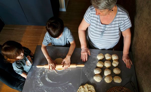 A nagyi és az unokák készítik a pitetésztát.. - Fotó, kép