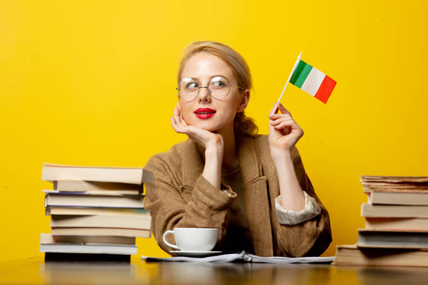 blondýna žena s vlajkou Itálie a knihy na žlutém pozadí - Fotografie, Obrázek
