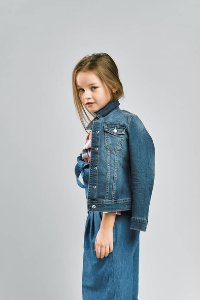 studio portrait of a little girl in a jeans suit - Фото, изображение