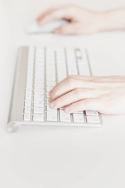 Lähikuva, Valkoihoisen naisen kädet, käyttäen langatonta näppäimistöä ja tietokoneen hiirtä, valkoisella taustalla. Business nainen, valikoiva keskittyä, kopioi tilaa käsitteitä - Valokuva, kuva