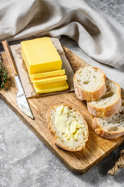Farm butter and fresh baguette with butter. Gray background.Top view. - Photo, Image