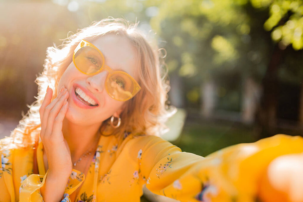 portrait of beautiful blond stylish white teeth smiling woman in yellow blouse wearing sunglasses making selfie photo, colorful summer fashion trend, bright spring sunny day, positive happy mood - Foto, imagen