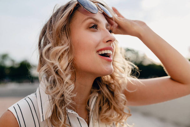 close-up retrato de jovem atraente mulher loira elegante na rua da cidade no verão vestido de estilo de moda usando óculos de sol, rindo com candid sorriso dentes brancos, ensolarado
 - Foto, Imagem
