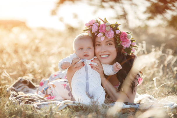 Happy mother with newborn baby boy outdoor - Photo, image